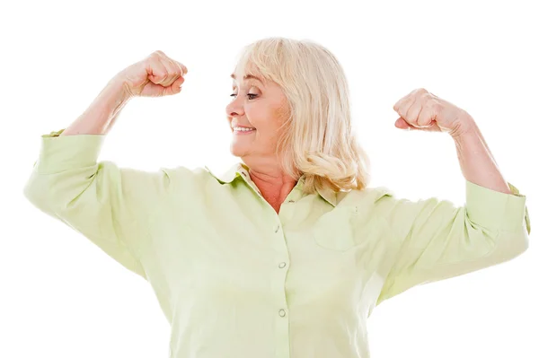 Äldre kvinna kontrollera hennes biceps — Stockfoto