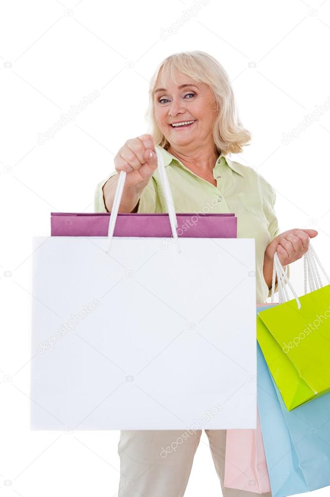 Senior woman stretching out shopping bags