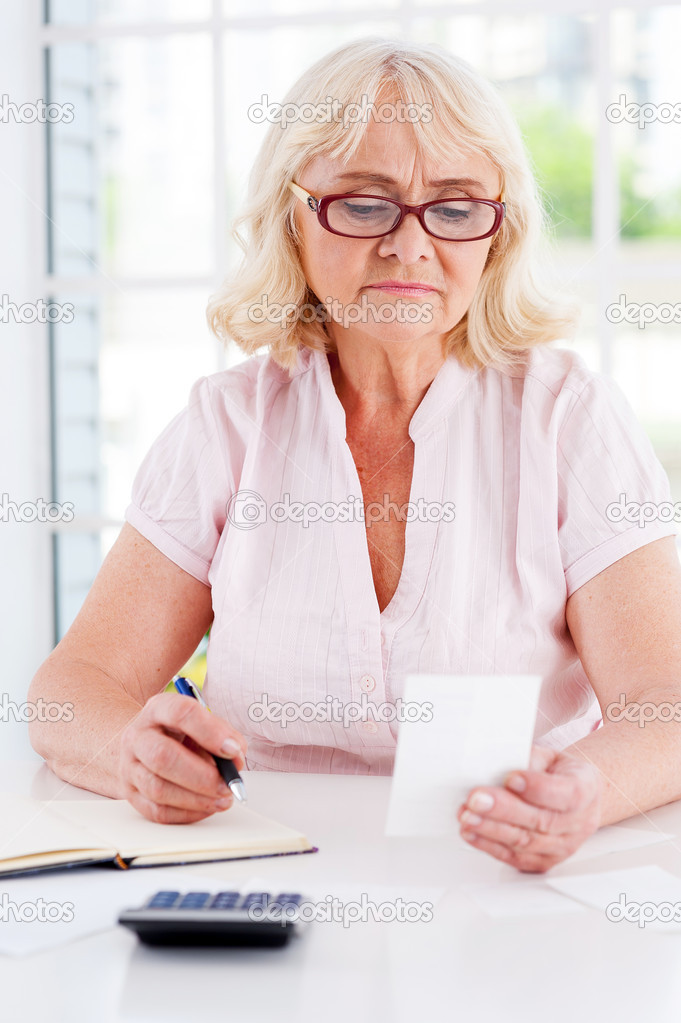 Senior woman holding bill