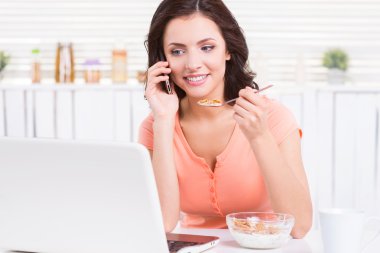 Kahvaltı ve dizüstü bilgisayarınızda çalışan kadın