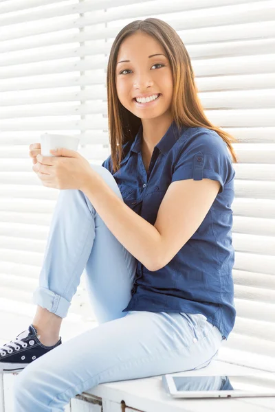 Asiatin sitzt auf der Fensterbank — Stockfoto