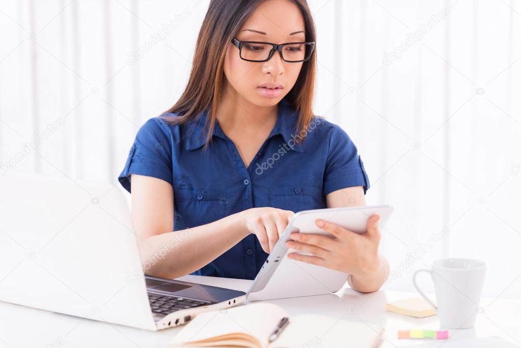 Asian woman working on digital tablet