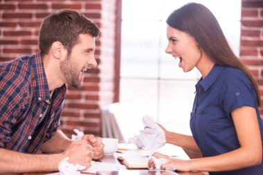 Kızgın adam ve kadın birbirlerine bağırıyorlar.