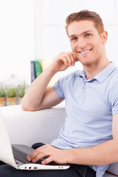 Man working on laptop on the couch — Stock Photo, Image