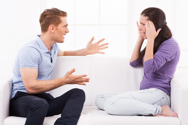 Man shouting and gesturing while woman sitting