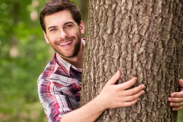 Hombre mirando desde el árbol — Foto de Stock