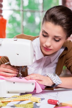 dikiş makinesi üzerinde çalışan tasarımcı