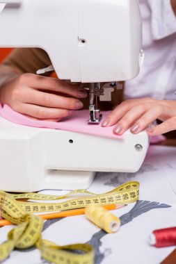 Dikiş makinesinin üzerinde çalışan moda tasarımcısı
