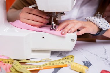 Dikiş makinesinin üzerinde çalışan moda tasarımcısı