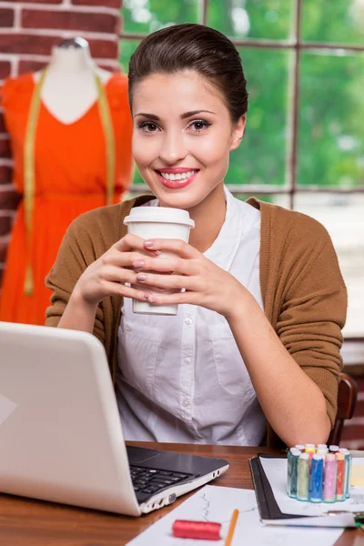 Fashion designer holding cup with hot drink — Stock Photo, Image