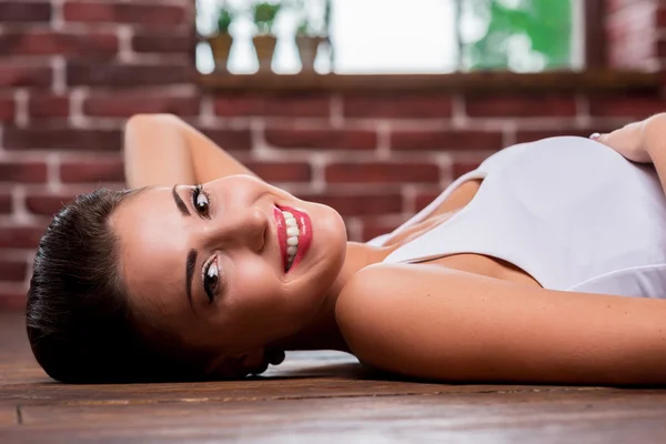 Femme couchée sur le plancher de bois franc — Photo