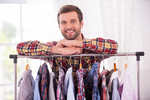 Homem inclinado no armário com camisas diferentes — Fotografia de Stock