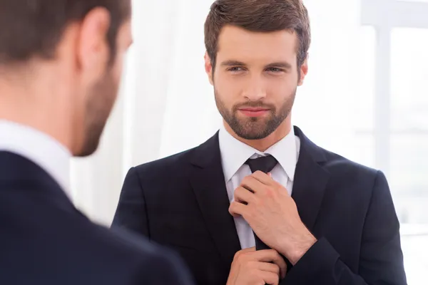 Man in formal wear adjusting his necktie — Stock Photo, Image