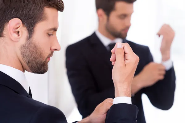 Hombre en ropa formal ajustando sus mangas — Foto de Stock