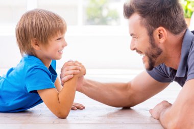 Father and son competing in arm wrestling clipart