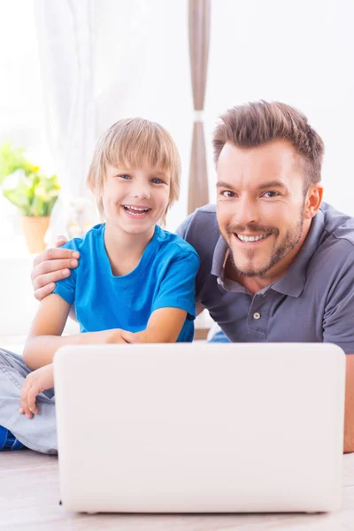 Vater umarmt seinen Sohn mit Laptop — Stockfoto