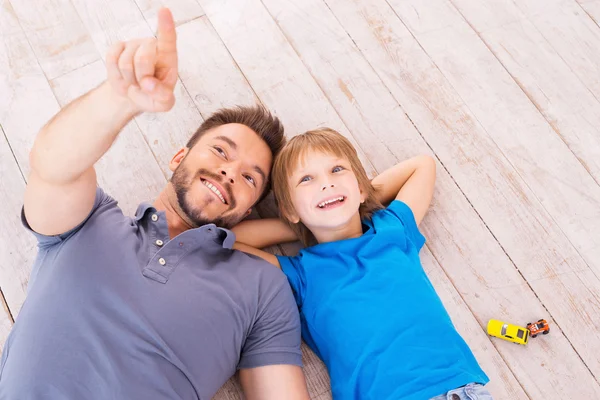 Pai e filho deitados no chão — Fotografia de Stock