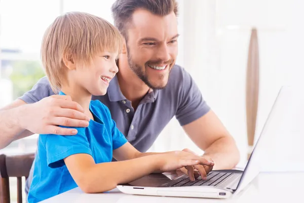 Pai e filho olhando para o laptop — Fotografia de Stock