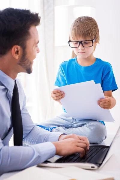 Man som arbetar på laptop med son — Stockfoto