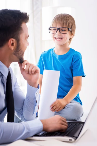 Man som arbetar på laptop med son — Stockfoto