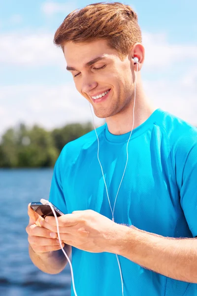 Sportovní muž s Kobaltová modř telefon — Stock fotografie