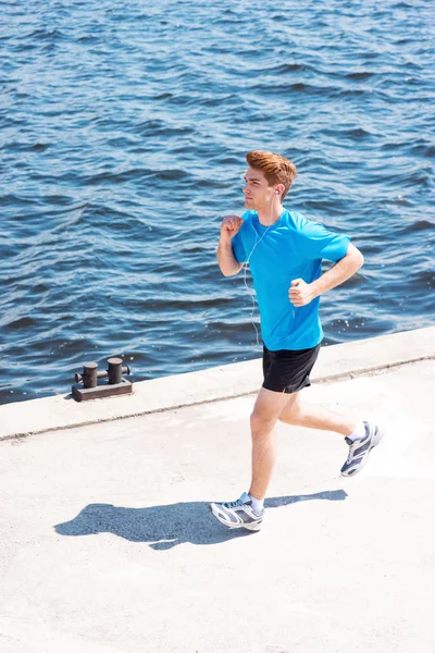 Man running along the riverbank — Stock Photo, Image