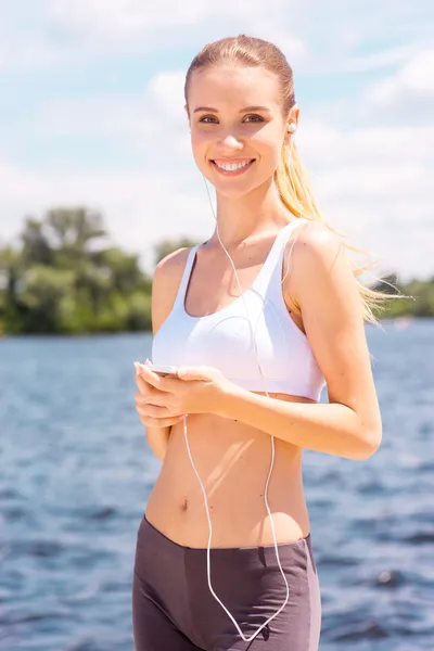 Mujer deportiva con teléfono inteligente. — Foto de Stock