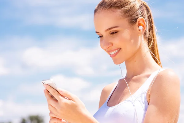 Frau in Sportkleidung mit Smartphone — Stockfoto