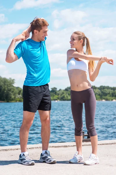 Mulher e homem fazendo exercícios de alongamento — Fotografia de Stock