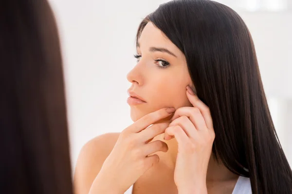 Mujer examinando su cara — Foto de Stock