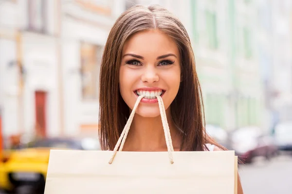 Woman carrying shopping bag by teeth — Stock Photo, Image