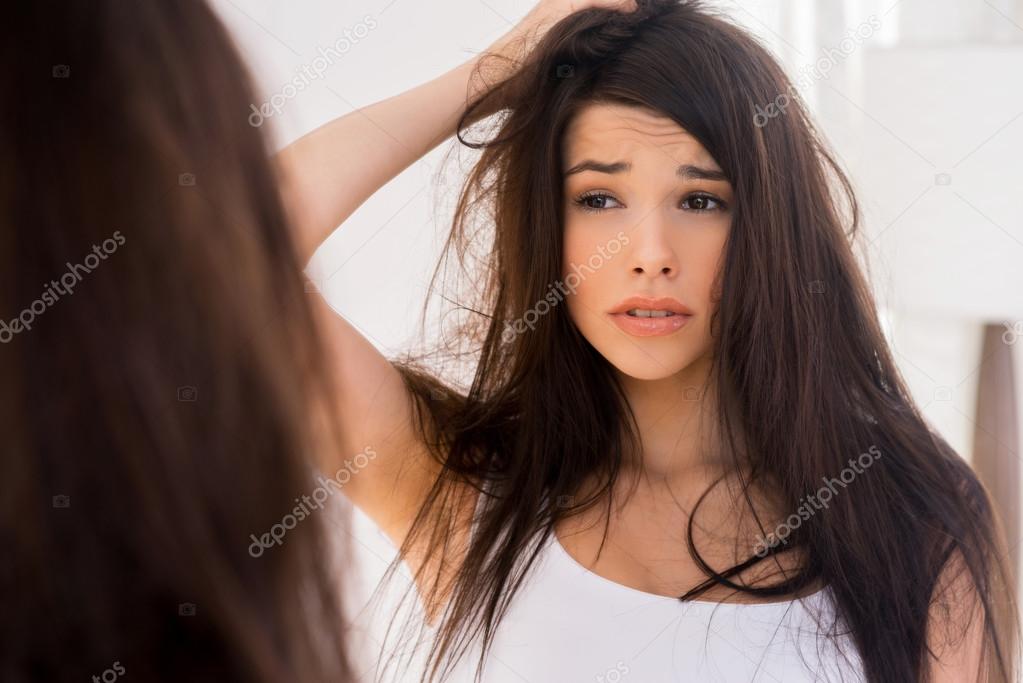 Frustrated woman looking at her reflection