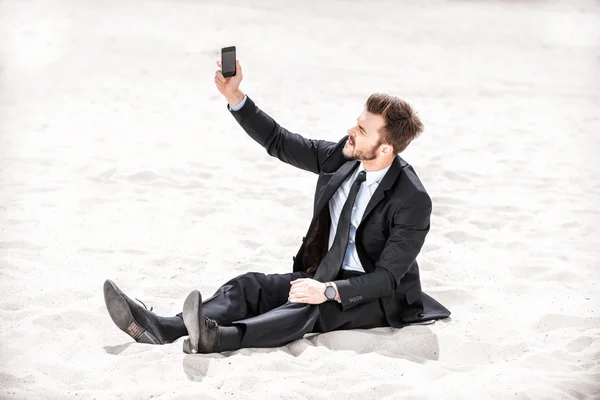 Businessman searching for mobile signal in desert — Stock Photo, Image