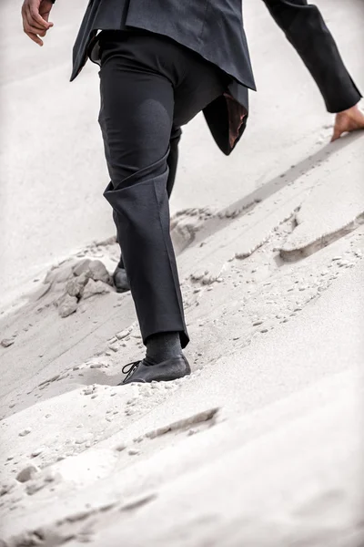 Hombre en ropa formal levantándose por la duna del desierto —  Fotos de Stock