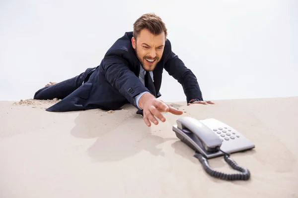 Affärsman stretching hand till telefon — Stockfoto