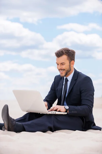 Mann in offizieller Kleidung arbeitet in der Wüste am Laptop — Stockfoto