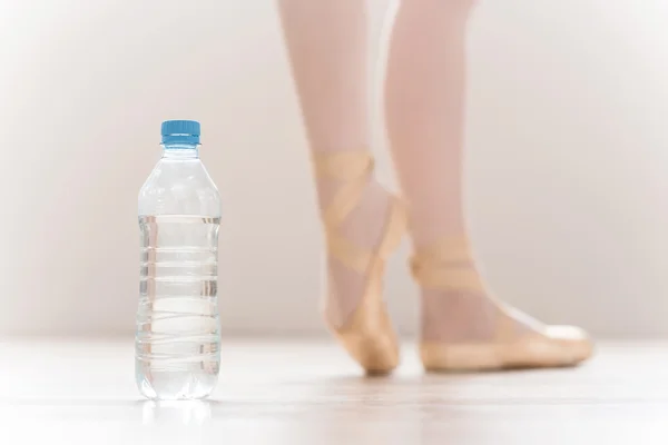 Flasche mit Wasser und Ballerinas Beine — Stockfoto