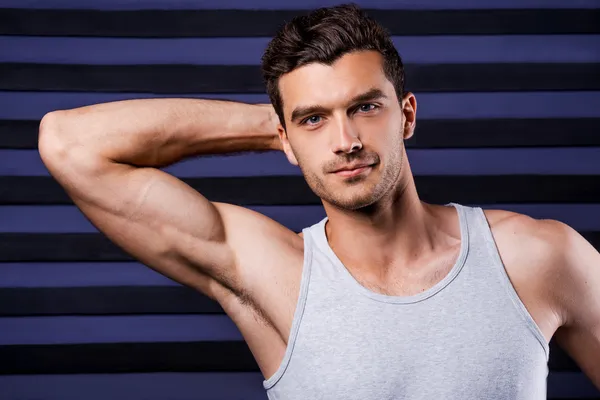 Man in tank top holding hand behind head — Stock Photo, Image