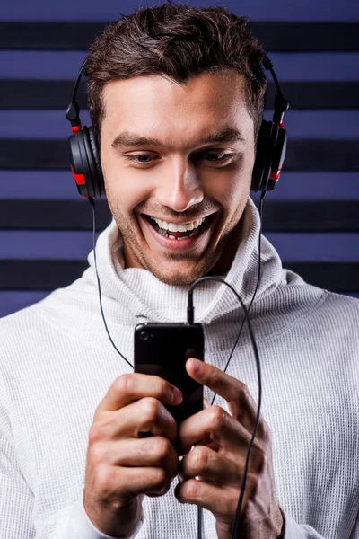 Muž v sluchátka držící mp3 přehrávač — Stock fotografie