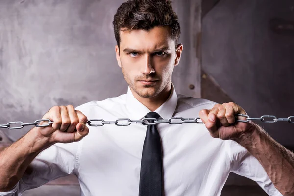 Hombre con camisa y corbata tratando de romper una cadena —  Fotos de Stock