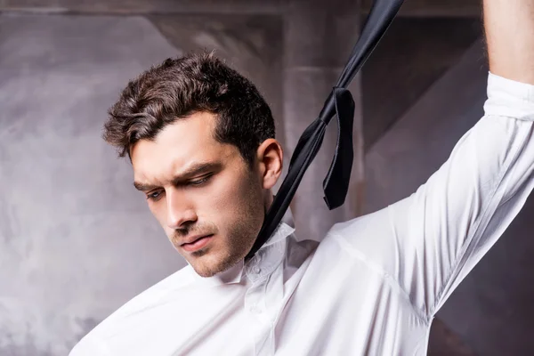 Man in formalwear taking off his necktie — Stock Photo, Image