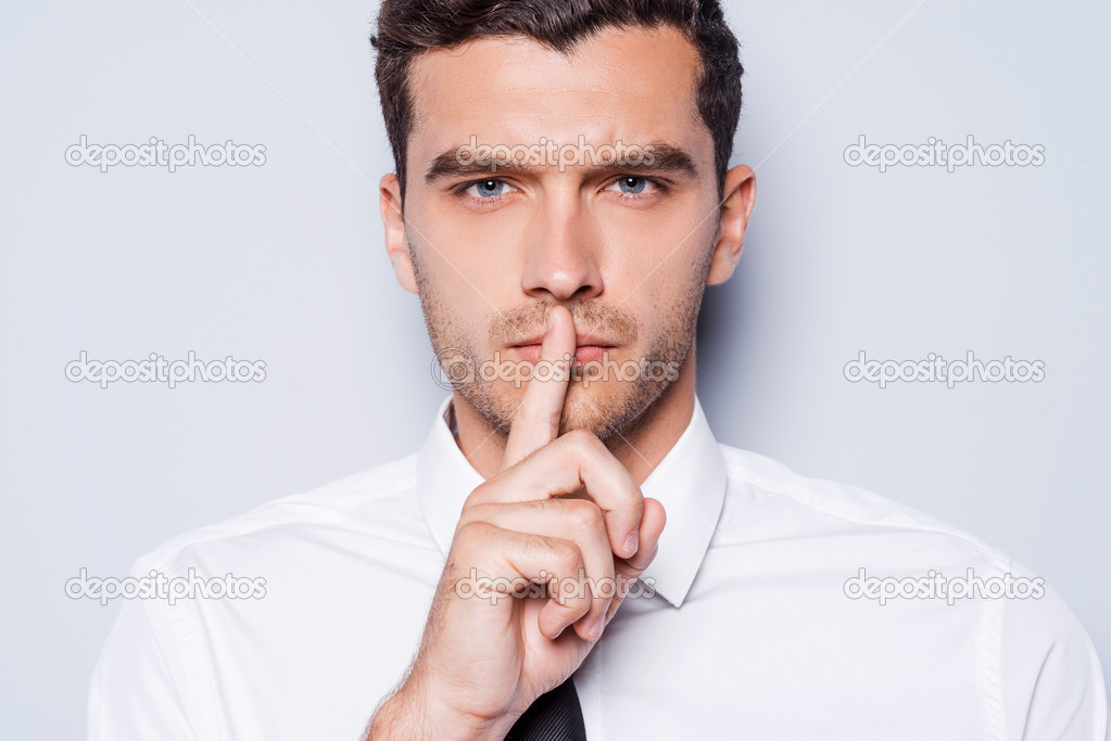 Man holding finger on lips