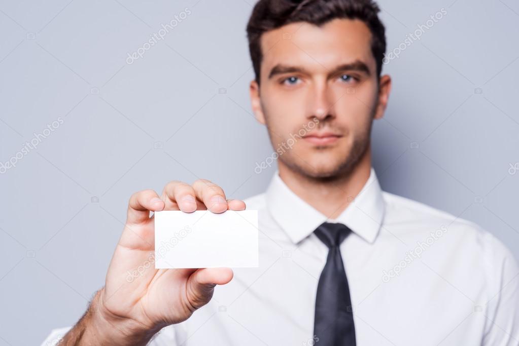 Man in shirt and tie showing business card
