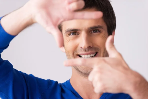 Man in blauwe trui gebaren vinger frame — Stockfoto