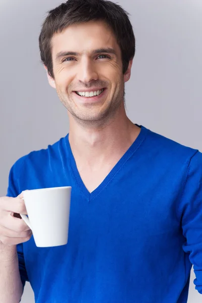 Człowiek w niebieski sweter trzymając kubek kawy — Zdjęcie stockowe