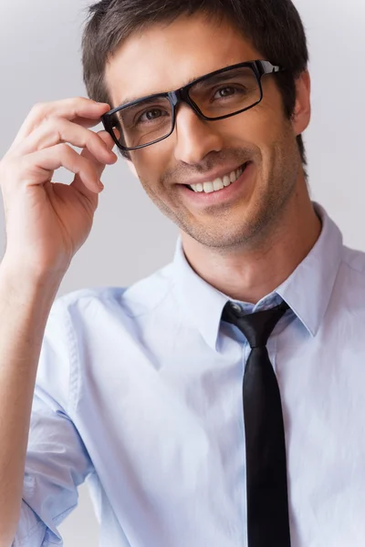 Uomo in camicia e cravatta che regola i suoi occhiali — Foto Stock