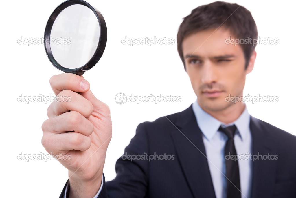 Man looking through magnifying glass.