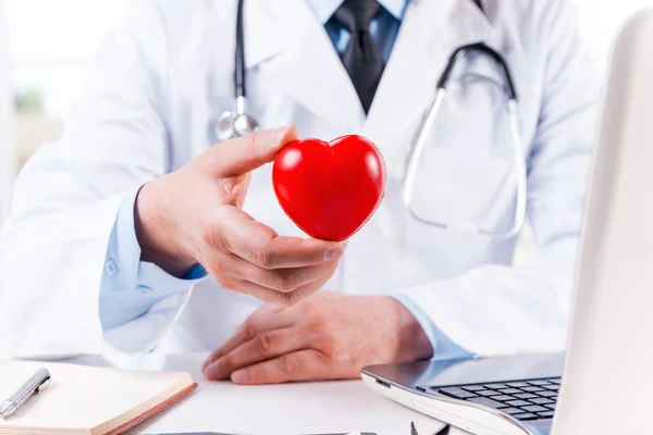 Doctor sosteniendo corazón forma juguete — Foto de Stock