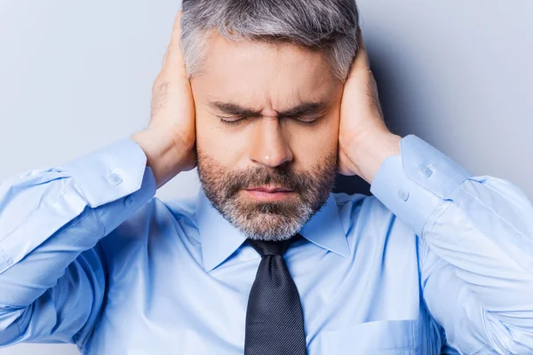 Uomo in camicia e cravatta che copre le orecchie con le mani — Foto Stock