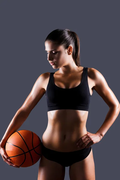Vrouw in sportkleding bedrijf basketbal bal — Stockfoto